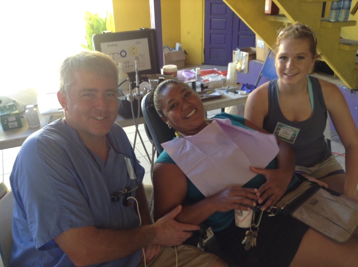 Dr.David Landgren and his daughter Claire, 16, of Hastings, Nebraska, are on their first dental mission to Belize and both have seen it as the experience of a lifetime. Dr. Landgren spoke of the "dichotomy" that exists on Ambergris Caye between the extreme poverty of San Mateo and the luxe life in resorts along the coast. Here they are working on Suyapa Leslie of San Pedro. 